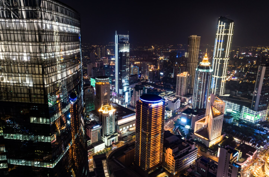 most expensive cities in the world skyline at night with dense illuminated skyscrapers
